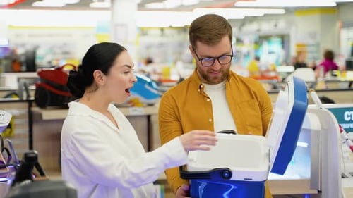 Young Couple Buying Portable Refrigerator for Travel in Appliances Store