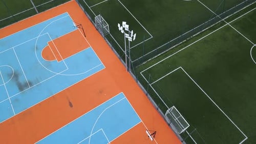 Aerial View of Outdoor Basketball and Soccer Courts with Vibrant Blue Orange and Green Colors The