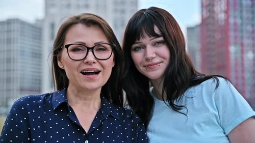 Two Smiling Women in Urban Cityscape Setting