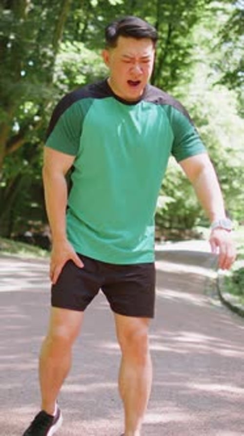 Japanese Runner Athlete Man with Muscle Pain in Park Trauma Injury While Jogging Leg Muscle Cramp
