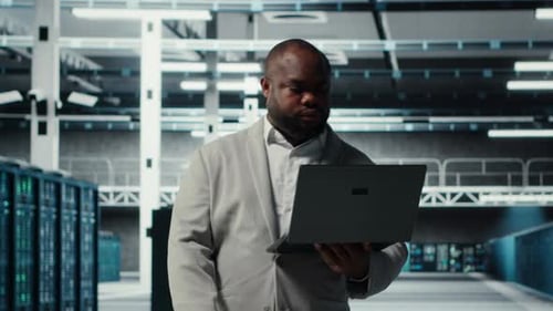 Technician Walks in Data Center Configuring Storage Devices for Minimal Latency