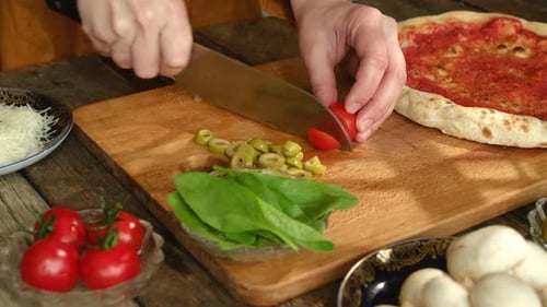 Hands Cutting Cherry Tomato for Pizza Preparation