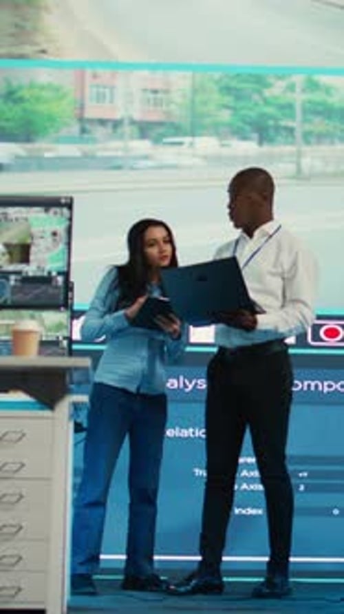 Vertical Video Diverse Team Monitoring Traffic in the City with CCTV System Footage
