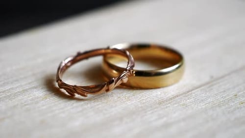 Two golden wedding bands lying on the surface