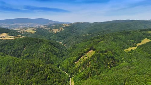 Lush green hills under clear blue sky.