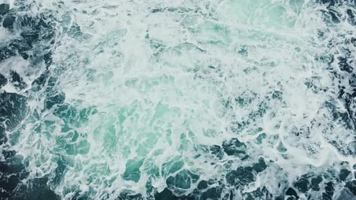 Les eaux de l'océan tourbillonnent autour de la côte rocheuse et pittoresque, les vagues de la mer se brisent sur les rochers