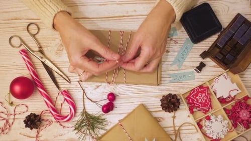 Hands Tying Ribbon Around Christmas Gift