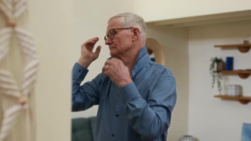 Senior Man Adjusts Shirt Collar