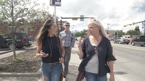 Women friends enjoying sunny weekend walk and talk in the city together