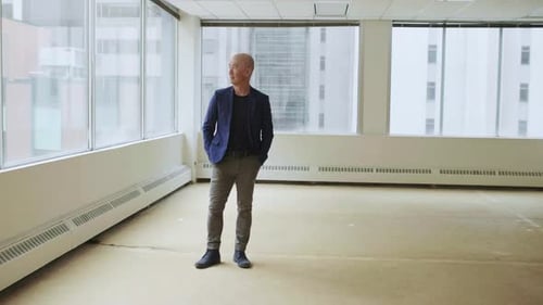 Man Looking Out of Window in Empty Office Adult