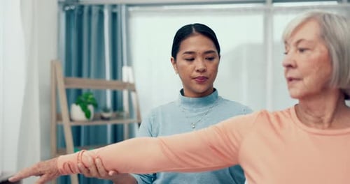 Therapist Helping Senior Woman Stretch Arm
