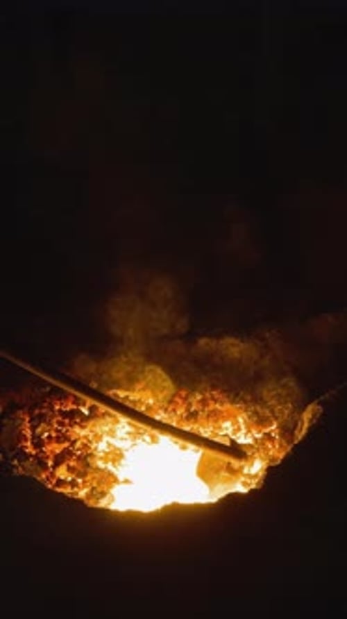 Dark Foundry Scene with Stirring Molten Metal