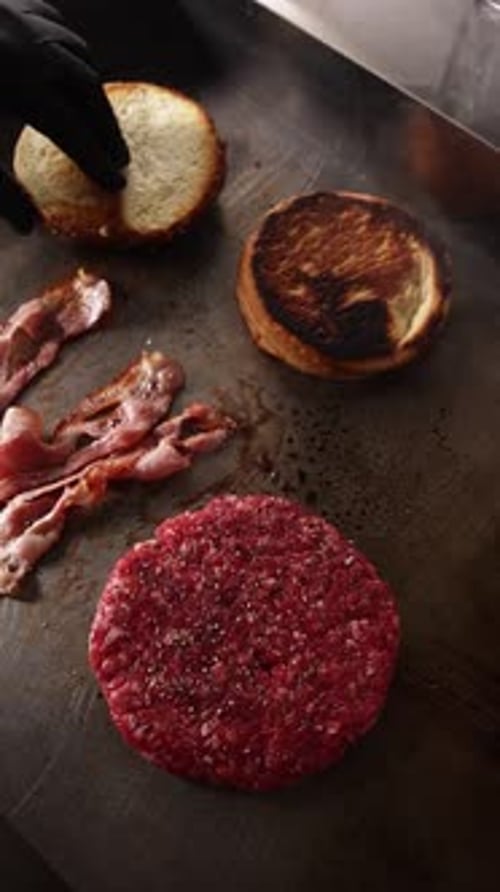 Burger ingredients cooking on flat top grill