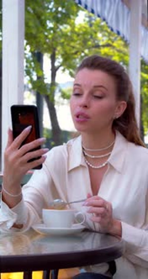Woman Video Chatting with Coffee at Outdoor Cafe