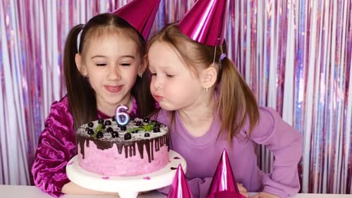 Two Cheerful Girls Celebrating a Birthday with Cake