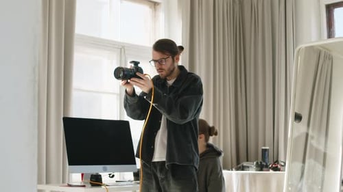 Young Photographer Working with Male Model in Studio