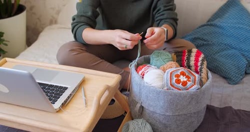 Young Adult Crocheting in Bedroom