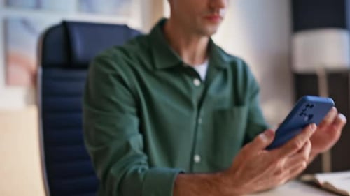 Young Adult Concerned Using Phone and Laptop at Desk