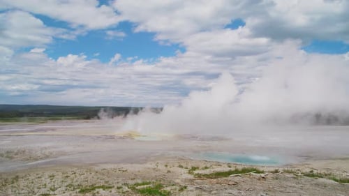 Weitläufiges Geysirbecken unter wolkengefülltem Himmel in Yellowstone
