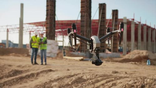 Closeup View of Quadcopter with Spinning Propellers in Foreground Quadcopter Filming Construction