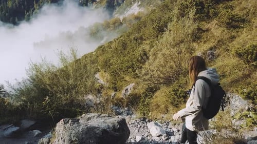 Beautiful Female Traveler Walks Through the Forest to the Mountains Higher Than Clouds Incredibly