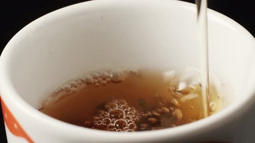 Verter leche en un té negro inglés para el desayuno en una taza de vidrio Beber té caliente con leche saludable