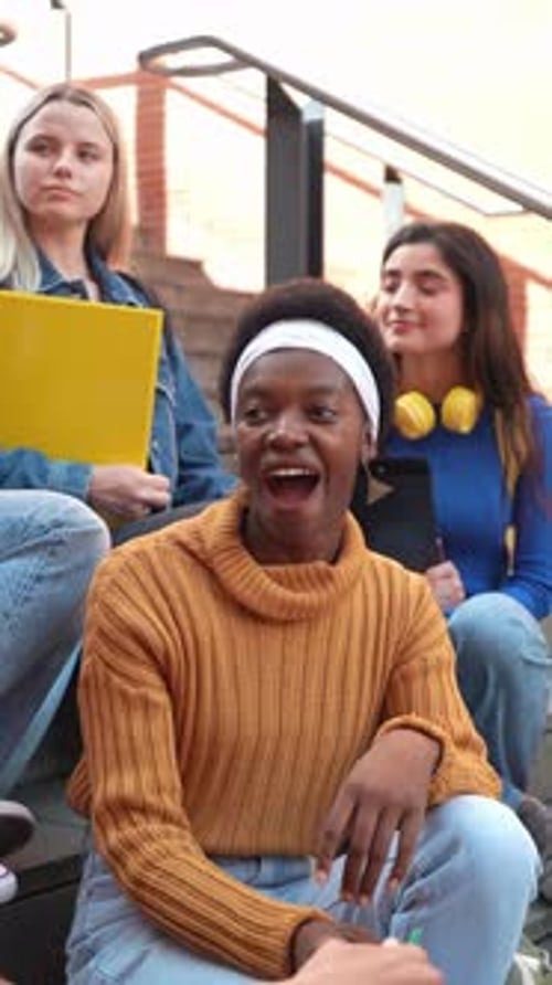 Multiethnic Students Laughing and Chatting Together on Campus Stairs