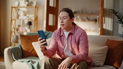 Man Relaxing on Couch with Phone Video Call