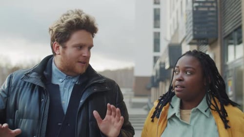 Two People Walking and Talking in City