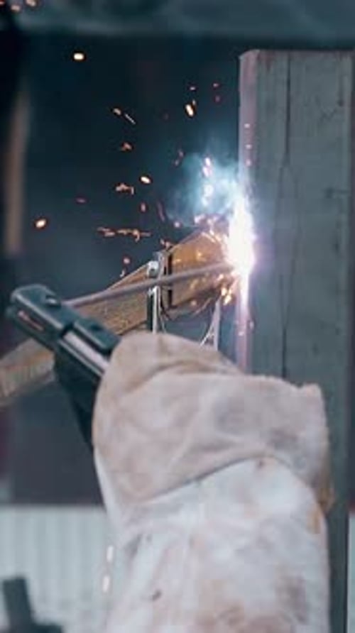 Slow Motion Close View Hand with Welding Machine at Fence