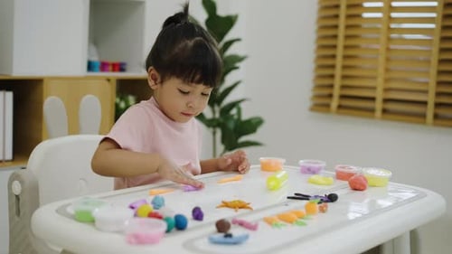 Young Girl Plays with Colorful Modeling Clay