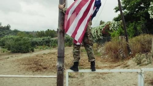 Man in Military Uniform Raising US Flag