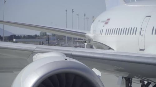 Nahaufnahme von Flugzeugabgasen und sich drehenden Strahlturbinen, während das Flugzeug am Terminal geparkt ist