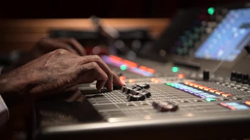 Sound Engineer Adjusting Controls on Sound Board 6064 Years