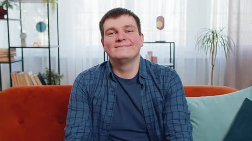 Smiling Man Sitting on Couch in Living Room