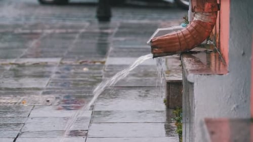 Urban Gutter Spout Drainage on Rainy Day