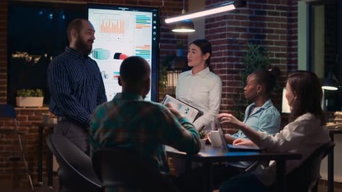 Team Discusses Project Around Table at Night