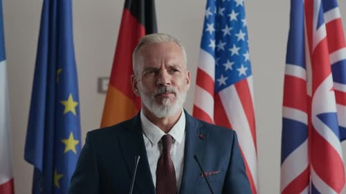 Man Speaking at Podium with International Flags