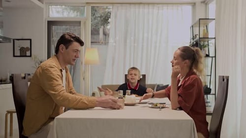 Couple Arguing at Dining Table, Child in Background