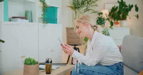 Blonde Woman Using Phone on Couch Indoors