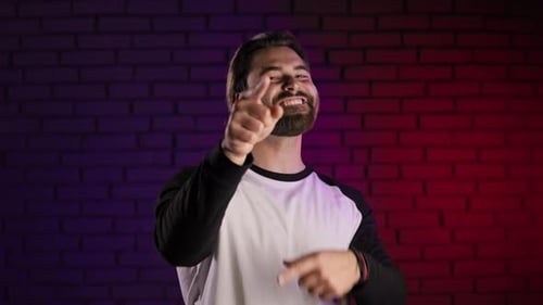 Positive Man Smiling on Camera and Pointing with Fingers