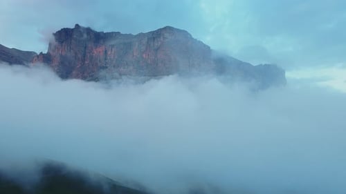 Cloudcovered Mountain with Blue Sky Backdrop Creating a Mystical Atmosphere
