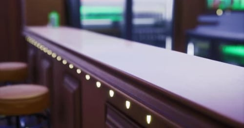 Modern Bar Counter with Soft Lighting and Wooden Finish in a Social Setting
