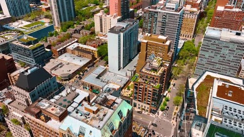 Flight over the tops of low and high-rise buildings in the densely built neighborhood.
