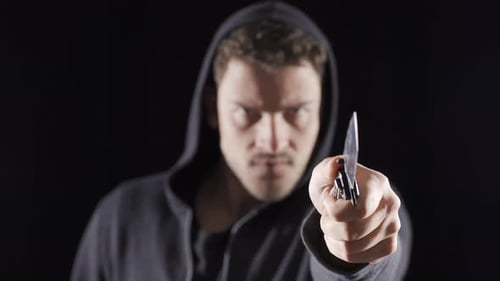 Aggressive man is making moves with a knife.