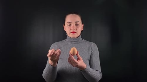 Uma mulher interagindo com um objeto isolado no fundo preto