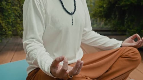 Man Meditates Outdoors in Lotus Position on Yoga Mat