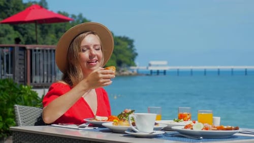 Travel Woman Enjoying the Beautiful Sea View on Buffet Breakfast