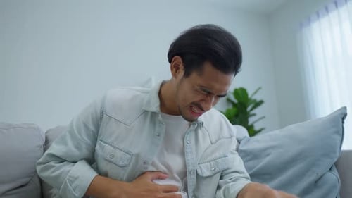 Man Suffering from Stomach Pain on Couch