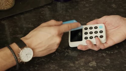 Hands Swiping Card Through Reader Close Up